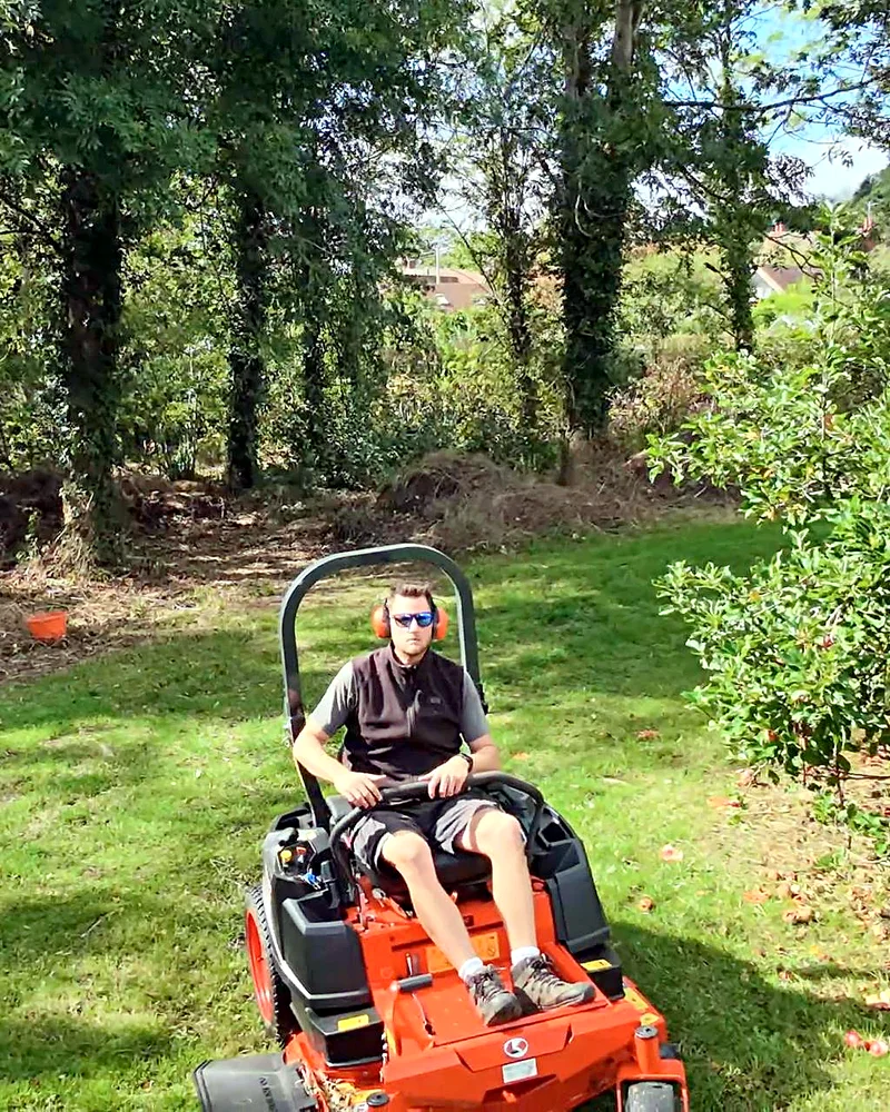 Tom on the zero turn under the trees